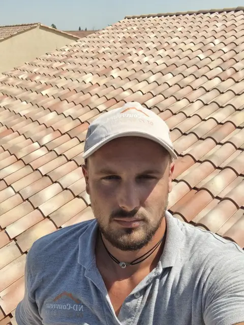 Dylan Naveri, couvreur, sur une toiture en tuiles